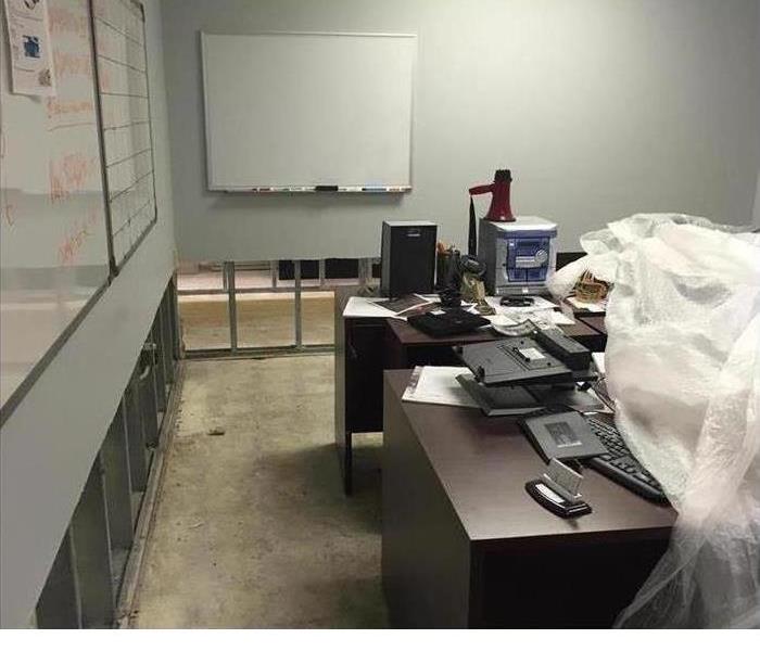 An office showing the drywall was removed 2 feet up from the floor