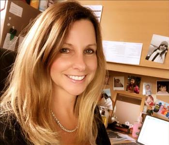 A photo of the owner Jennifer Sullivan sitting at her desk